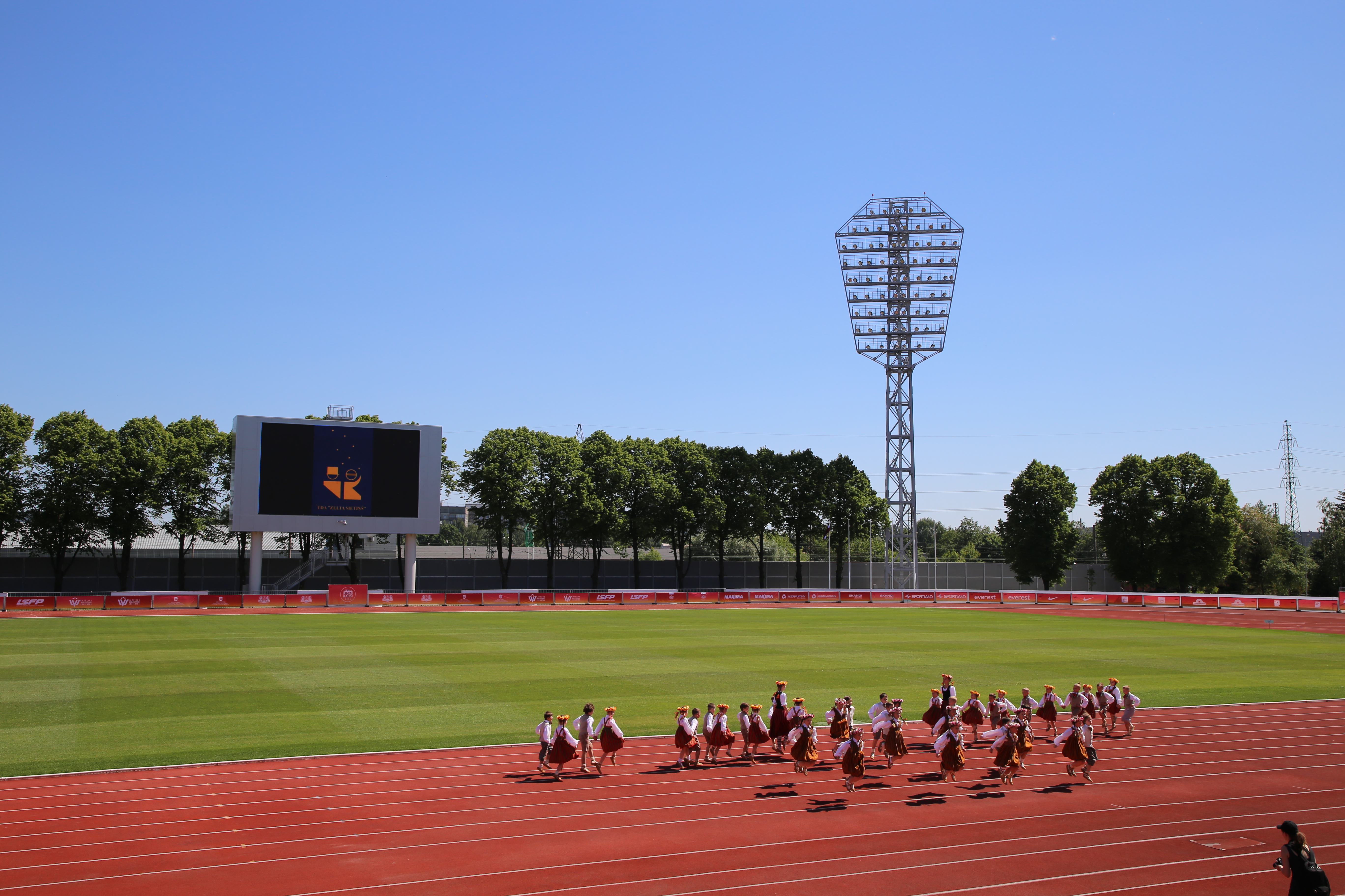 Attēls: bērnu tautas deju ansamblis dejo Daugavas stadionā