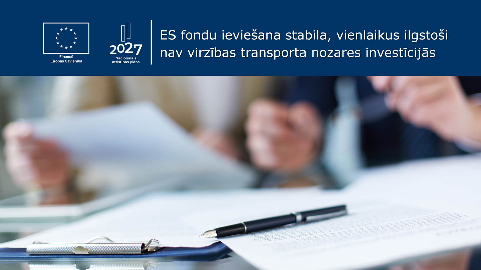 Divi cilvēki pie galda pārskata dokumentus, priek&scaron;plānā tintes pildspalva ar dokumentiem. Teksts "ES fondu ievie&scaron;ana stabilu, vienlaikus ilgsto&scaron;i nav virzības transporta nozares investīcijās"