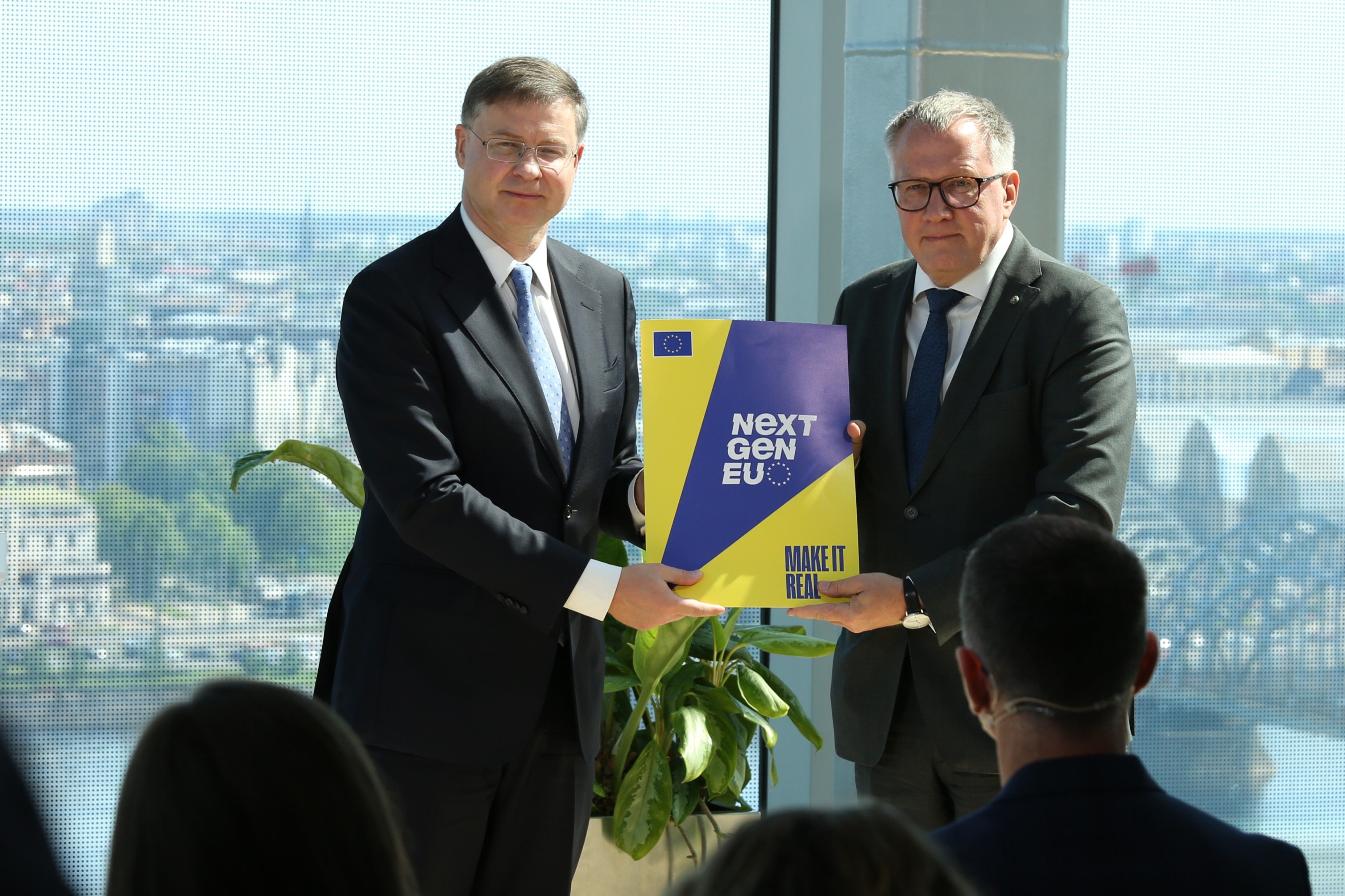 EK priek&scaron;sēdētājas izpildvietnieks Valdis Dombrovskis nodod 2. maksājuma mapi finan&scaron;u ministram Arvilam A&scaron;eradenam