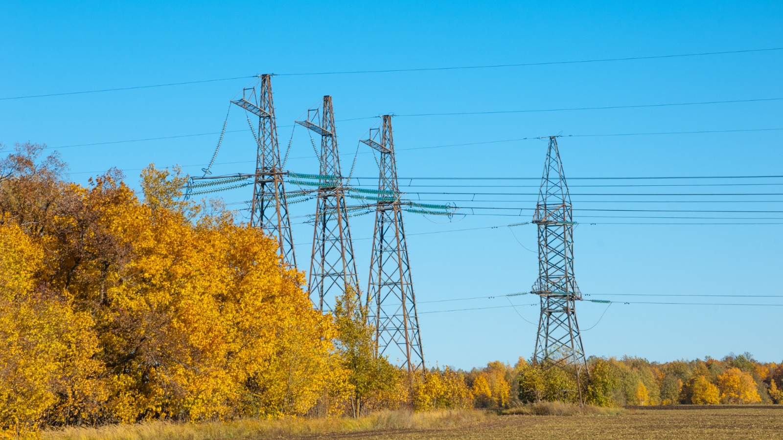 Klaj&scaron;, apstrādāts lauks ar elektrības stabiem un vadiem