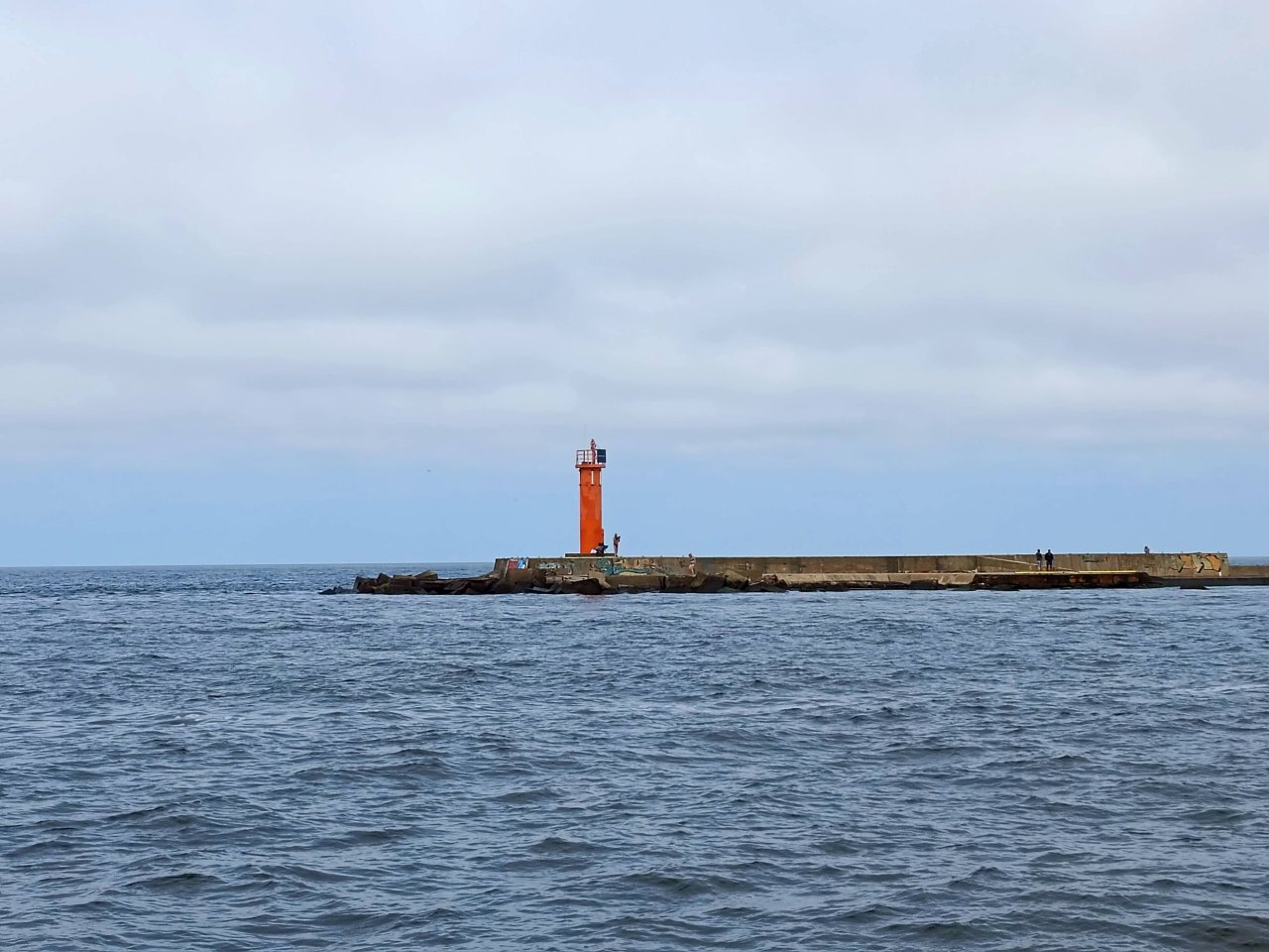 sarkana bāka uz mola jūrā