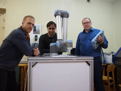 Pētnieki blakus prototipam