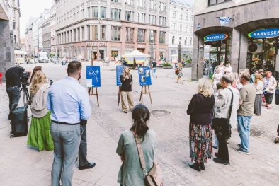 Marta Kotello, Rīgas domes Ārtelpas un mobilitātes komitejas priekšsēdētāja, un apmeklētāji pasākumā uz Vaļņu ielas