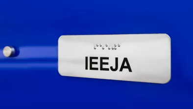 Uz zila fona hromēta plāksnīte ar melnu uzrakstu 