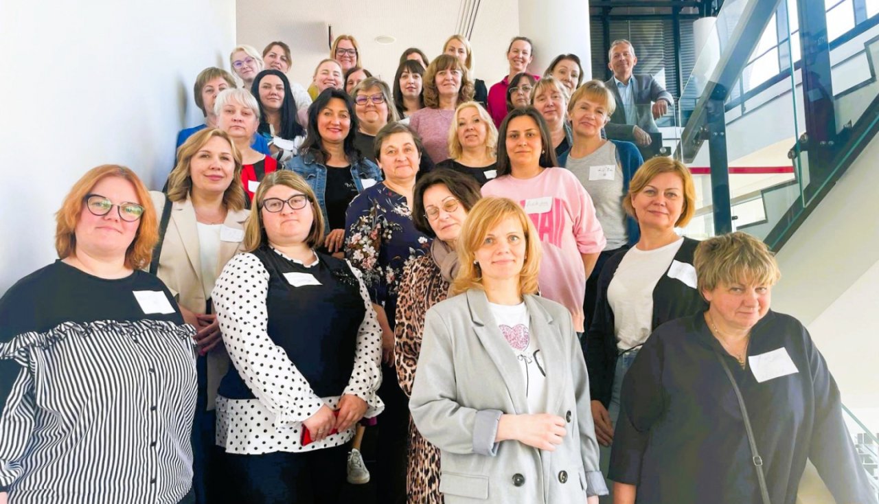 Daudz sievietes stāv uz trepēm un pozē fotogrāfam