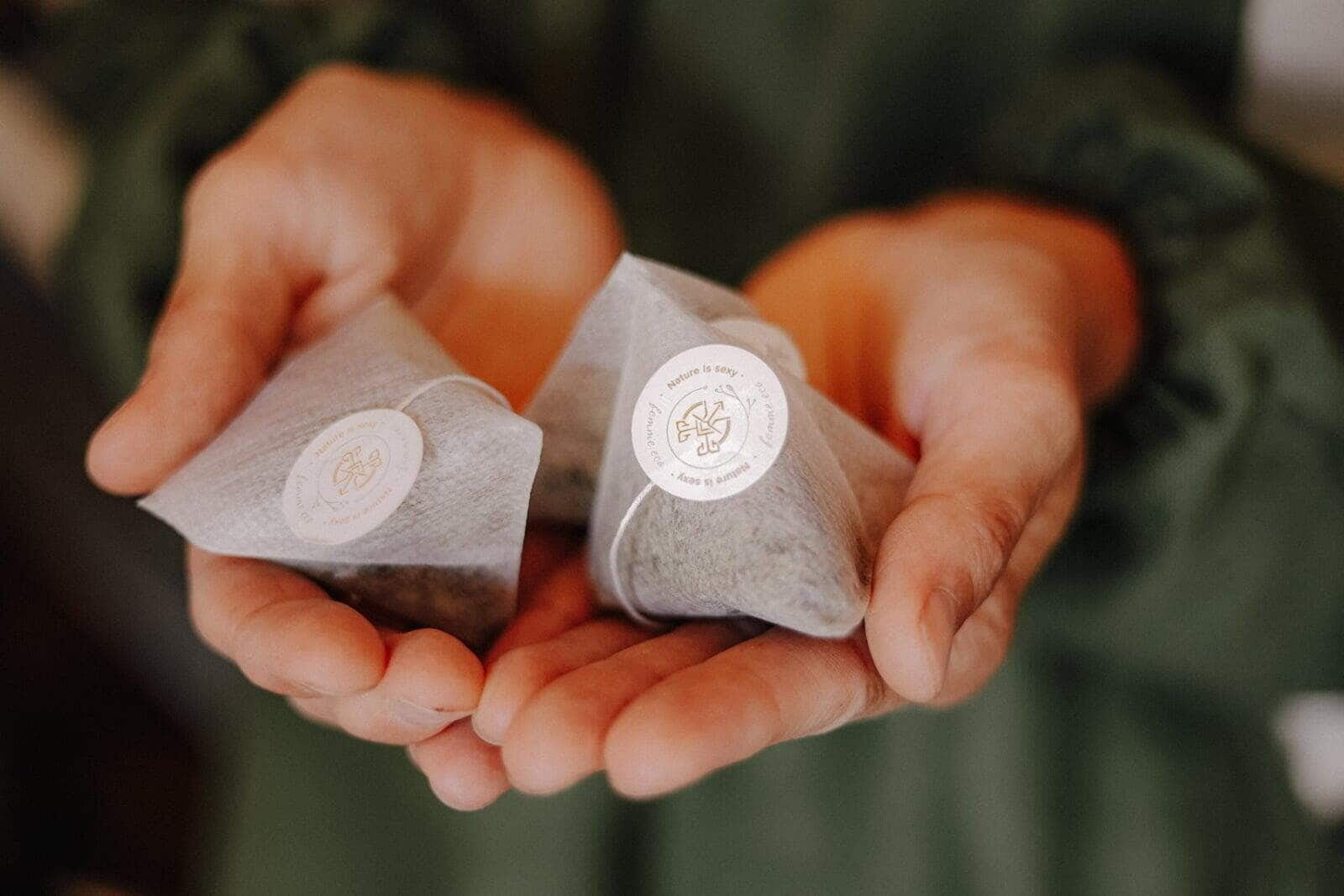 Tējas paciņas rokās